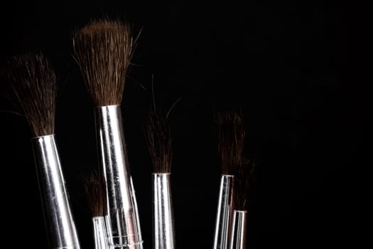 Paint brushes close up on a dark background, copy space