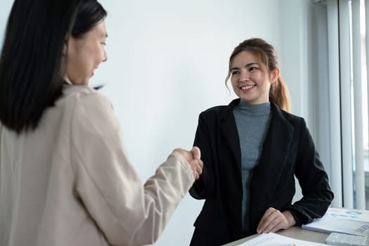 Handshake of employees after successful planning strategy marketing in the office.