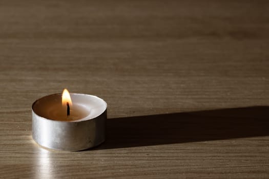 The Little candle on a wooden table with copy space