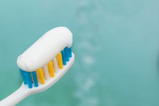 Tooth brush and white toothpaste close up with copy space