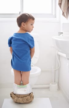 Boy kid, potty training and bathroom with thinking, diaper and pants on floor for learning, development and progress. Child, family home and back in toilet with ideas, hygiene or solution with nappy.