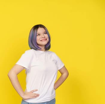 Happy Asian Teenager Girl, Dressed In White Shirt, Isolated Portrait On Yellow Background. Teenage Life, With Girl's Expressive Smile Creating Lively And Vibrant Atmosphere. Copy Space For Your Text. High quality photo