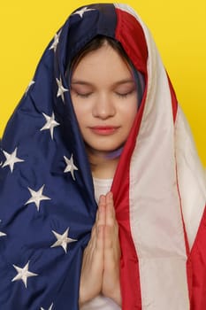 Asian Muslim Teenager Girl Using American Flag As Hijab, Combining Elements Of American And Islamic Identity. Against Yellow Background, Harmonious Multiculturalism And Personal Expression In The Youth. High quality photo