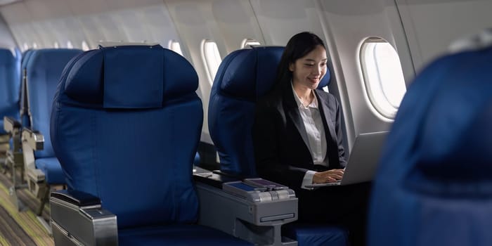 businesswoman flying and working in an airplane in first class, Man sitting inside an airplane using laptop.