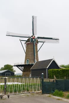 Windmill in a Dutch village. Vertical frame.