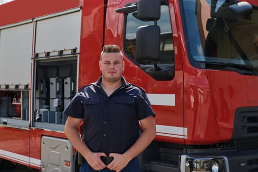 A confident firefighter strikes a pose in front of a modern firetruck, exuding pride, strength, and preparedness for emergency response.