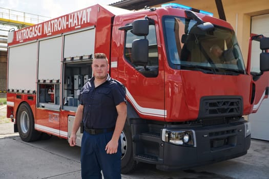 A confident firefighter strikes a pose in front of a modern firetruck, exuding pride, strength, and preparedness for emergency response.