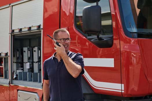 A dedicated firefighter, captured in a moment of communication, stands before a modern firetruck, showcasing the seamless integration of technology in emergency response.