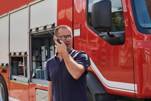 A dedicated firefighter, captured in a moment of communication, stands before a modern firetruck, showcasing the seamless integration of technology in emergency response.