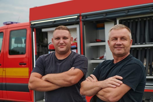 A skilled and dedicated professional firefighting team proudly poses in front of their state of the art firetruck, showcasing their modern equipment and commitment to ensuring public safety