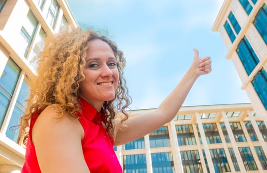 Portrait happy fasion woman shows thumb up against the sky and looking and looks sideways and up. concept of good and happy