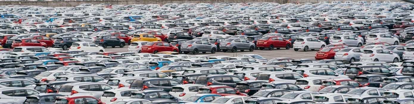 Lamchabang, Thailand - July 02, 2023 At a sunny car factory, new cars occupy rows in a distribution center. The top view captures the crowded parking lota symbol of modern manufacturing.