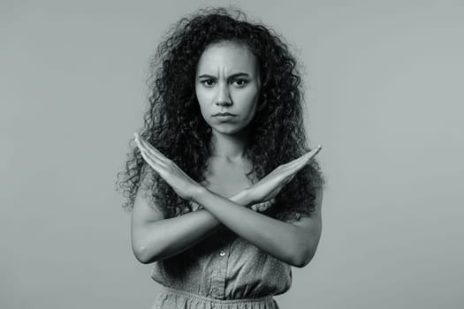 No, never, pretty curly woman disliking and rejecting gesture by stop crossing hands sign. Cute girl disapproving sign make negation sign