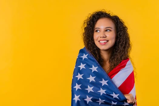 Happy woman with national USA flag on yellow background. American patriot, 4th of July - Independence day celebration, election, America, labor. US banner. High quality photo