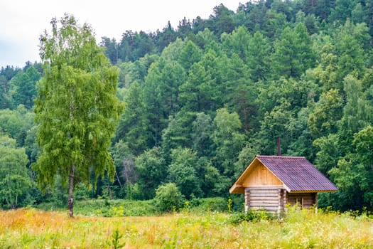 Wooden bathhouse in the beautiful Russian nature by the river