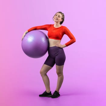 Full body length gaiety shot athletic and sporty young woman with fitness exercising ball in standing posture on isolated background. Healthy active and body care lifestyle.