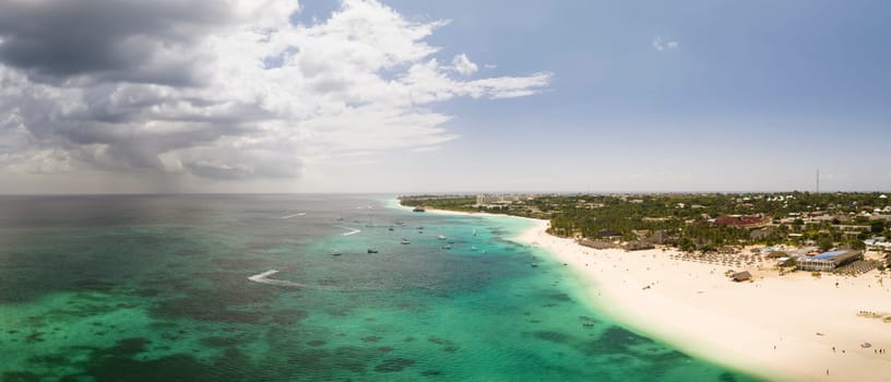 Typical Zanzibar beach where tourists and locals mix together of colors and joy, concept of summer vacation, aerial view of zanzibar, Tanzania