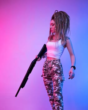 a cheeky girl with braided dreadlocks on her head in neon light with an gun in neon light