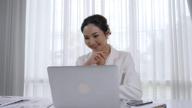Young businesswoman sitting on the workspace desk using laptop computer for internet online content writing or secretary remote working from home. Vivancy