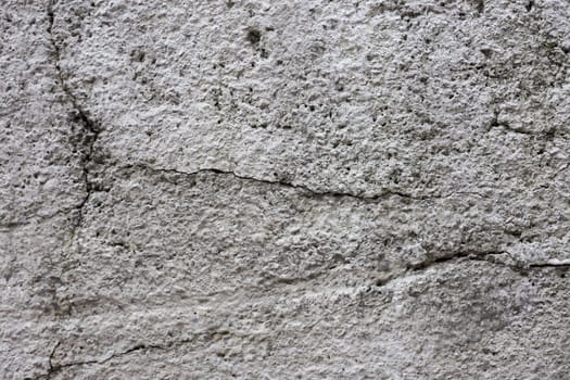 Old gray cracked stucco on the wall.