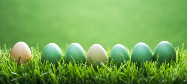 A harmonious line of speckled Easter eggs in various shades of green nestled in vibrant green grass, symbolizing the freshness of spring.