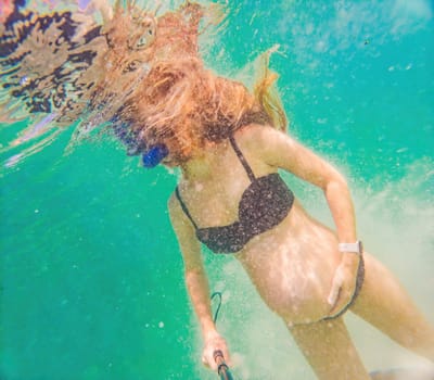 In an ethereal underwater scene, a pregnant woman gracefully floats, embodying the beauty of maternity beneath the tranquil surface of the sea.