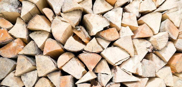 Old tree, logs, firewood harvested for the winter for the heating season, a beautiful background with textured wooden boards close-up.