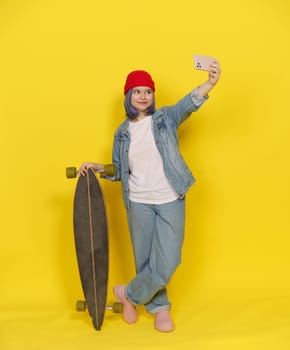 Stylish Teen With Longboard Make Selfie, Girl In Red Hat With Skateboard And Mobile Phone On Yellow Background. Teenager Immersed In Contemporary Lifestyle Of Skateboarding And Digital Connectivity. High quality photo