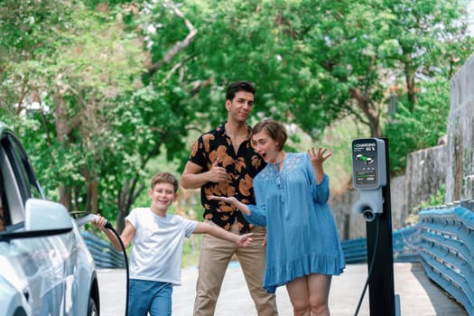 Family road trip vacation with electric vehicle, lovely family recharge EV car with green and clean energy. Natural and eco friendly car travel for sustainable environment. Perpetual