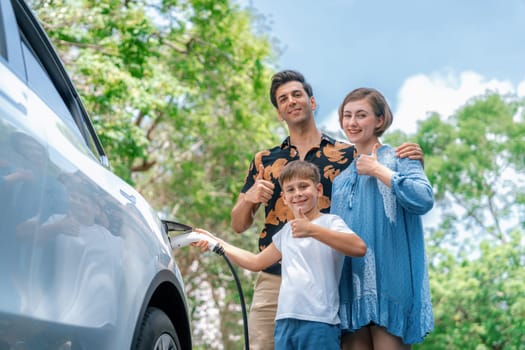 Family road trip vacation with electric vehicle, lovely family recharge EV car with green and clean energy. Natural and eco friendly car travel for sustainable environment. Perpetual