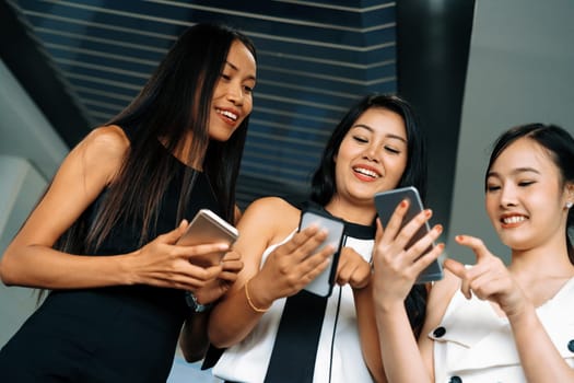 Three women friends having conversation while looking at mobile phone in their hands. Concept of social media, gossip news and online shopping. uds