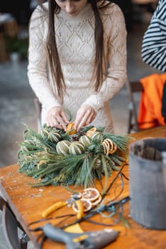 Engaged in a hands-on experience, a young lady crafts Christmas ornaments in a workshop. High quality photo