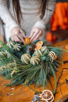 Actively participating in a crafting session, a young woman makes Christmas decorations. High quality photo