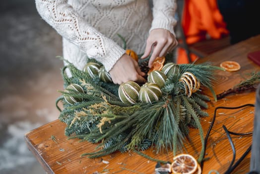 A young woman is actively involved in a workshop crafting Christmas ornaments. High quality photo