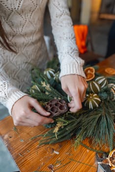 A young woman takes part in a crafting workshop, making festive Christmas ornaments. High quality photo