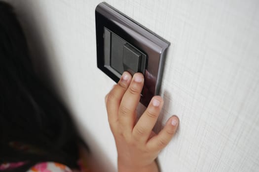 child finger turning on lighting switch with copyspace .