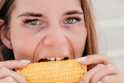 Healthy vegetarian hipster woman in summer outfit eat grilled corn and look to camera. Sexy lady on sea beach sunset or ocean sunrise. Travel, explore, active yoga and meditation lifestyle concept.