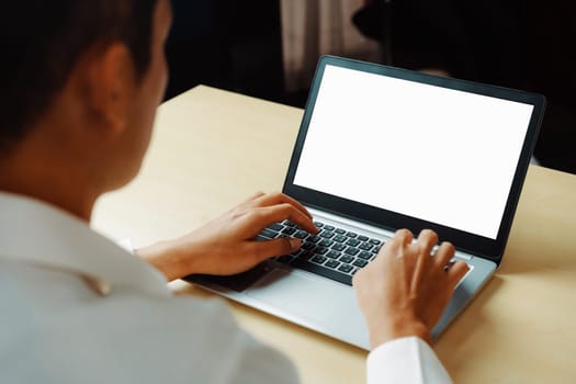 Business person or office worker using laptop computer while sitting at desk. uds