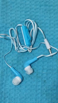 headphones with wire, background object,blue and white, inexpensive. High quality photo