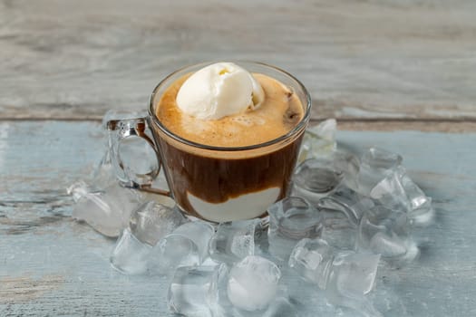 Affogato coffee with vanilla ice cream in a glass cup on wooden table