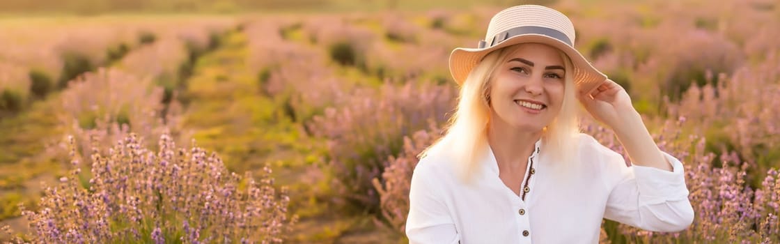 Young woman standing on a lavender field with sunrise on the background.