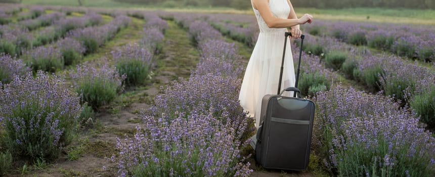 woman with luggage in lavender field.