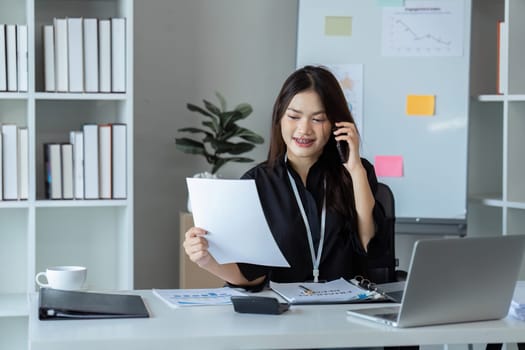 Businesswoman on the phone and using laptop at office. Businesswoman professional talking on mobile phone.