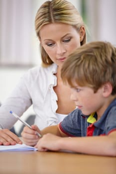 Teacher, student and help with school work in classroom, question and think of answer for education and knowledge. Teaching, learning and woman with boy in class, study and problem solving for test.