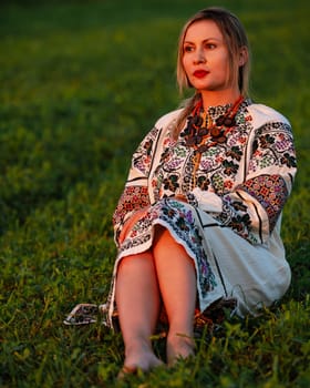 Embroidered and unique petticoat, a girl walks barefoot in the field in an embroidered shirt, Ukrainian clothes and traditions.