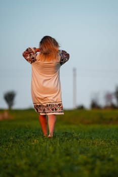 Embroidered and unique petticoat, a girl walks barefoot in the field in an embroidered shirt, Ukrainian clothes and traditions.