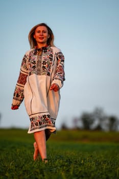 Embroidered and unique petticoat, a girl walks barefoot in the field in an embroidered shirt, Ukrainian clothes and traditions.