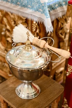 A large silver bowl and sprinkler for consecration in the church, elements of church rites.