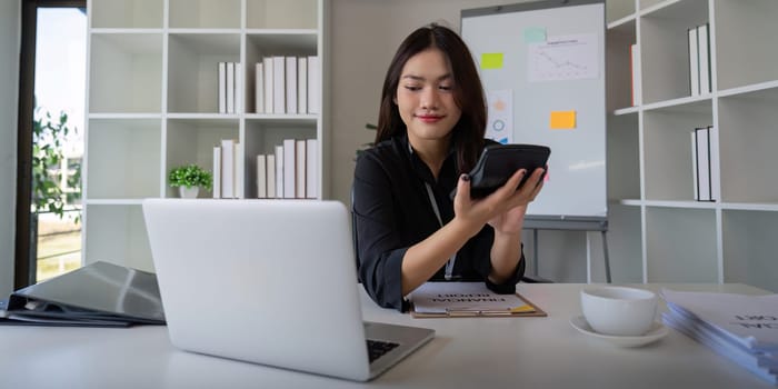 Businesswoman accountant using calculator and laptop for financial data saving in office room, Business financial, tax, accounting concept.