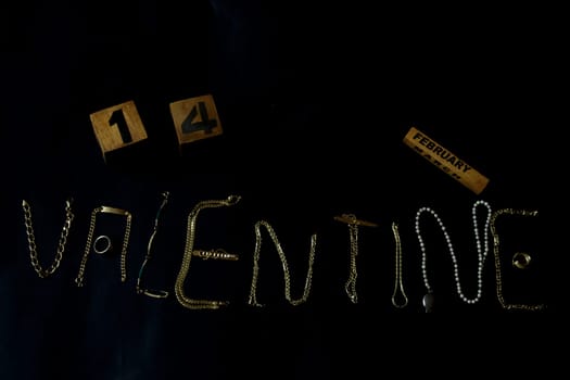 valentine's day concept with valentine written with gold jewelry